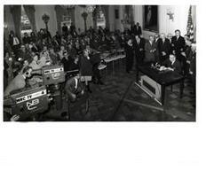 ["Black and white photograph of Lyndon B. Johnson at a bill-signing ceremony with television cameras.  Others present include: Carl Albert, Hubert H. Humphrey, and John W. McCormack."]