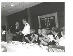 ["Black and white photograph of Carl Albert giving a speech at the United States Naval League Council in McAlester, Oklahoma on Armed Forces Day 1976."]