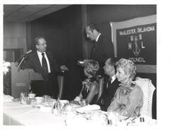 ["Black and white photograph of Carl Albert giving a speech at the United States Naval League Council in McAlester, Oklahoma on Armed Forces Day 1976."]