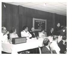 ["Black and white photograph of Carl Albert giving a speech at the United States Naval League Council in McAlester, Oklahoma on Armed Forces Day 1976."]