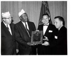 ["Black and white photograph of Carl Albert being presented a Distinguished Service Citation plaque by the DAV."]