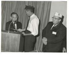 ["Black and white photograph of Carl Albert being presented a Distinguished Service Citation plaque by the DAV."]