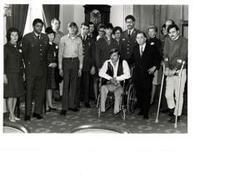 ["Black and white photograph of Carl Albert with some unidentified disabled veterans."]