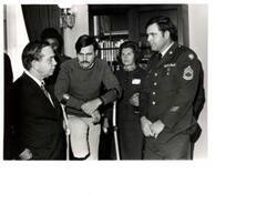["Black and white photograph of Carl Albert with a disabled veteran and others."]