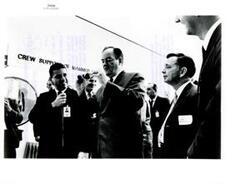 ["Black and white photograph of Richard S. Johnston NASA Chief, Crew Systems Division, discussing space equipment with Vice-President Hubert Humphrey at the Manned Spacecraft Center in Houston, Texas.  Carl Albert is also present.  Included with this item (not pictured) is a note from Carl Albert to James E. Webb, NASA Administrator, thanking him for the tour of the Manned Spacecraft Center and requesting twelve additional copies of another photo (listed as S-65-28373) not with item from that event."]
