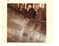 ["Color photograph of Hubert H. Humphrey listens to a discussion of the Gemini III Spacecraft from Charles W. Matthews manager of the Gemini Program Office, Manned Spacecraft Center, Houston, July 13, 1965 Carl Albert and A. S. Mike Monroney included."]