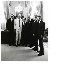 ["Black and white photograph of Carl Albert with John McFall, Gerald R. Ford, John Rhodes, and others standing in an office."]