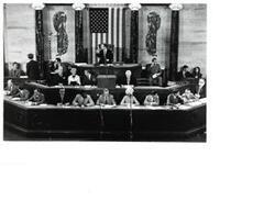 ["Black and white photograph of Carl Albert and others sitting in the House chamber."]