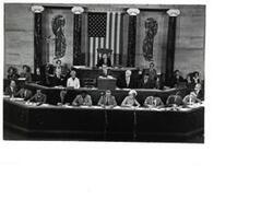 ["Black and white photograph of Carl Albert and others sitting in the House chamber"]