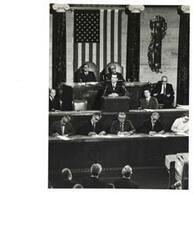 ["Black and white photograph of Group of men, including Carl Albert, in the House chamber."]