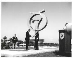 ["Black and white photograph of Astronaut Memorial Dedication Ceremonies. Admiral Bowles receives medallion from Roger Lewis. November 10, 1964"]