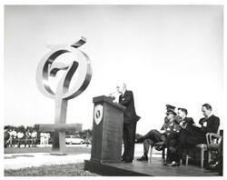 ["Black and white photograph of Astronaut Memorial Dedication Ceremonies. Dr. Edwin C. Welsh delivers keynote address. November 10, 1964.  Carl Albert is seated in the photograph."]