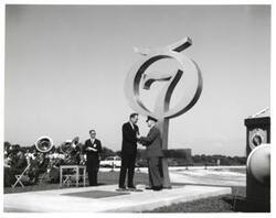 ["Black and white photograph of Astronaut Memorial Dedication Ceremonies. Gen. Ritland receiving medallion from Roger Lewis. November 10, 1964"]