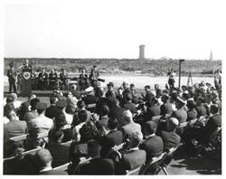["Black and white photograph of Astronaut Memorial Dedication Ceremonies. Major General Fulois (retired) being introduced. November 10, 1964.  Carl Albert seated behind speaker's podium."]