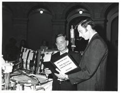 ["Black and white photograph of Carl Albert with unidentified man looking at the lunar rover."]