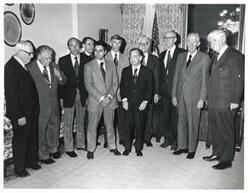 ["Black and white photograph of Carl Albert, Thomas P. O'Neill, and John J. McFall with a group in speaker's office. John Anderson, Olin Teague, and Leslie Arends are also pictured."]