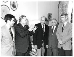 ["Black and white photograph of Thomas P. O'Neill with a group in Speaker's office."]