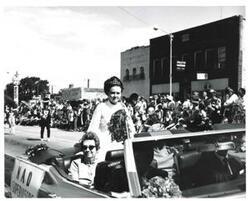 ["Black and white photograph of a group of people riding in a parade on Armed Forces Day in McAlester, Oklahoma. 1973"]