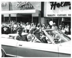 ["Black and white photograph of a group of people riding in a parade on Armed Forces Day in McAlester, Oklahoma. 1973"]