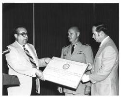 ["Black and white photograph of a presentation at a banquet on Armed Forces Day in McAlester, Oklahoma 1973"]