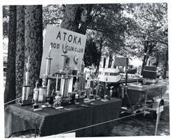 ["Black and white photograph of a trophy exhibit in McAlester, Oklahoma on Armed Forces Day. 1973"]