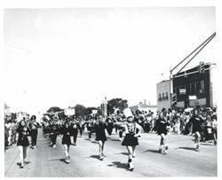 ["Black and white photograph of a band in parade in McAlester, Oklahoma on Armed Forces Day. 1973"]