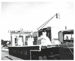 ["Black and white photograph of a parade in McAlester, Oklahoma on Armed Forces Day. 1976"]