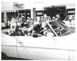 ["Black and white photograph of a parade in McAlester, Oklahoma on Armed Forces Day. Carl Albert and Henry Bellmon are pictured in 3845"]