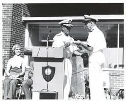 ["Black and white photograph of a ceremony at naval depot in McAlester, Oklahoma on Armed Forces Day."]