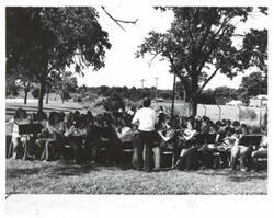 ["Black and white photograph of a student band performing in McAlester, Oklahoma on Armed Forces Day."]