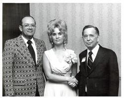 ["Black and white photograph of Carl Albert with an unidentified man and woman in McAlester, Oklahoma on Armed Forces Day."]