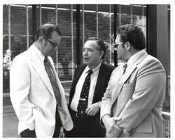["Black and white photograph of Carl Albert with two men in McAlester, Oklahoma on Armed Forces Day."]