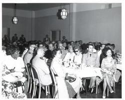 ["Black and white photograph of a banquet in McAlester, Oklahoma on Armed Forces Day. 1974"]