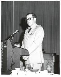 ["Black and white photograph of a speaker at a banquet in McAlester, Oklahoma on Armed Forces Day. 1974"]