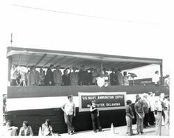 ["Black and white photograph of a speaker's stand at a parade in McAlester, Oklahoma on Armed Forces Day. 1974"]