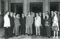 ["Black and white photograph print of Carl Albert posing with a large group of people."]