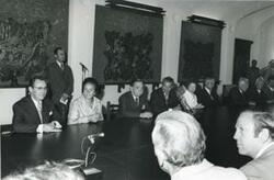 ["Black and white photograph print of Carl Albert and Mary Albert seated at a table with several others."]