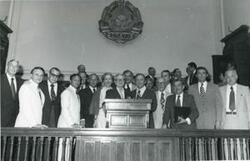 ["Black and white photograph print of Carl Albert posing with several men in a building in Romania. This is during the House delegation trip to the USSR, Romania, and Yugoslavia. August 1975"]