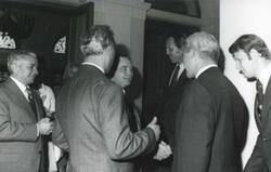 ["Black and white photograph print of Carl Albert shaking hands with a man while others look on. This is during the House delegation trip to the USSR, Romania, and Yugoslavia. August 1975"]