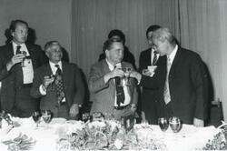["Black and white photograph print of Carl Albert drinking a toast with several men. House delegation trip. August 1975"]