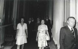 ["Black and white photograph print of  Carl Albert and Mary Albert walking down the hall with several others during House delegation trip. August 1975"]