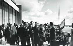 ["Black and white photograph print of a large group of people standing outside a building in Russia. House delegation trip. August 1975"]