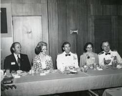 ["Black and white photograph of a banquet in McAlester, Oklahoma on Armed Forces Day. 1974"]