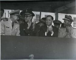["Black and white photograph of Carl Albert with military officers on a reviewing stand in McAlester, Oklahoma on Armed Forces Day 1969"]