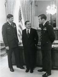 ["Black and white photograph of Carl Albert with two members of the Air Force's A-6 or A-8? in the Speaker's office. Officer on left's surname is Debellevue."]