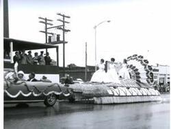 ["Black and white photograph of parade in McAlester, Oklahoma on Armed Forces Day. 1967. Not pictured is a note from U.S. Naval Captain R. M. Hanson to Carl Albert thanking him for participating in the Armed Service event; also a response letter from Carl Albert to Captain Hanson thanking him for the letter and his services are also not pictured."]