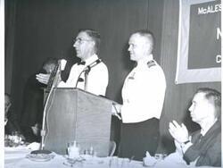 ["Black and white photograph of banquet in McAlester, Oklahoma on Armed Forces Day. 1967 Carl Albert near speaker's stand."]