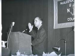 ["Black and white photograph of banquet in McAlester, Oklahoma on Armed Forces Day. 1967 Carl Albert is presenting a speech."]