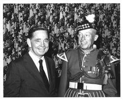 ["Carl Albert shown with a man wearing traditional Scottish clothing in McAlester, Oklahoma on Armed Forces Day. 1970"]