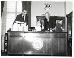 ["Black and white photograph of Carl Albert with unidentified people."]